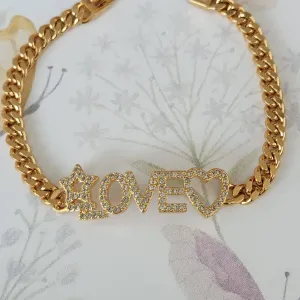 PULSEIRA DOURADA LOVE CRAVEJADA EM  MICROZIRCÔNIAS CRISTAL DETALHE CORAÇÃO E ESTRELA VAZADO