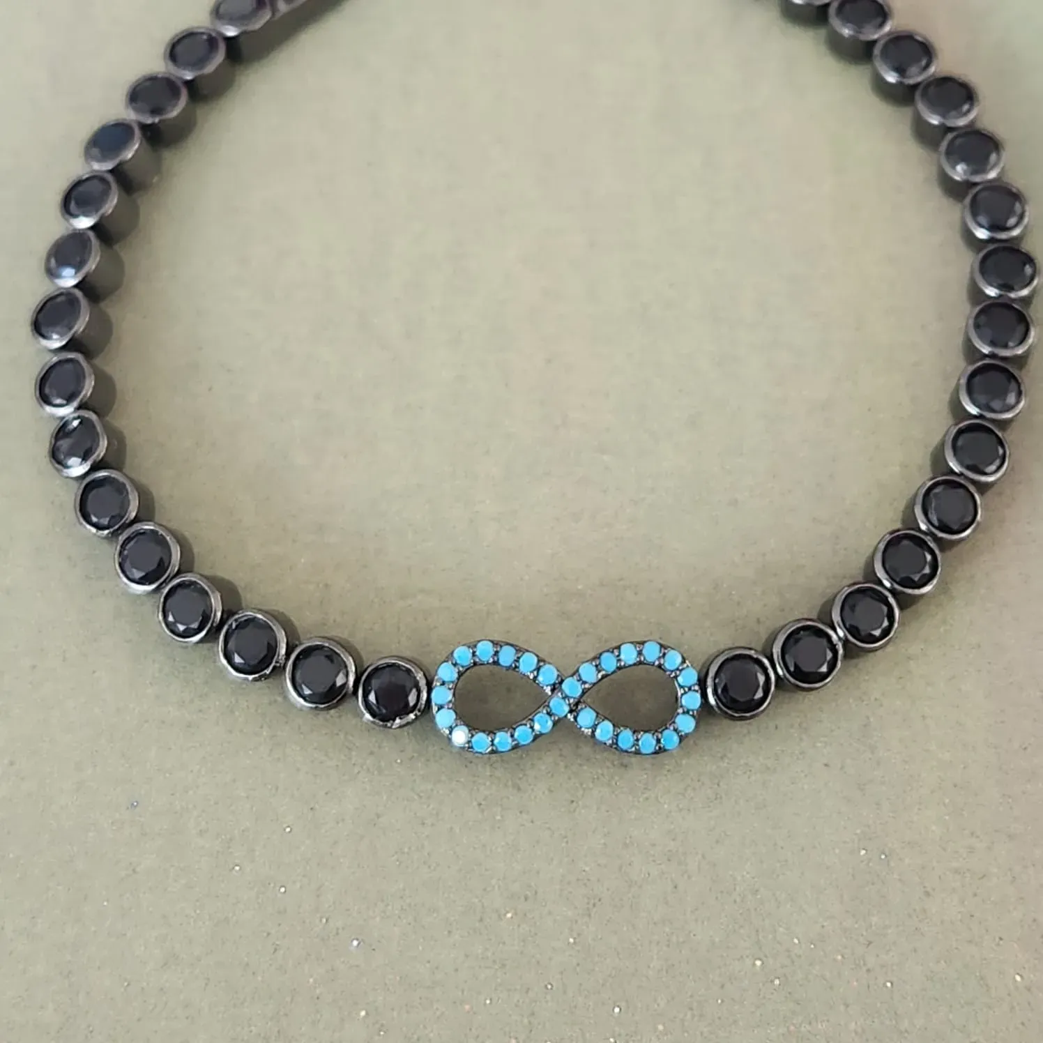 PULSEIRA RÓDIO NEGRO CRAVEJADO MICROZIRCÔNIAS TURQUESA SIMBOLO DO INFINITOE ZIRCÔNIAS NEGRAS